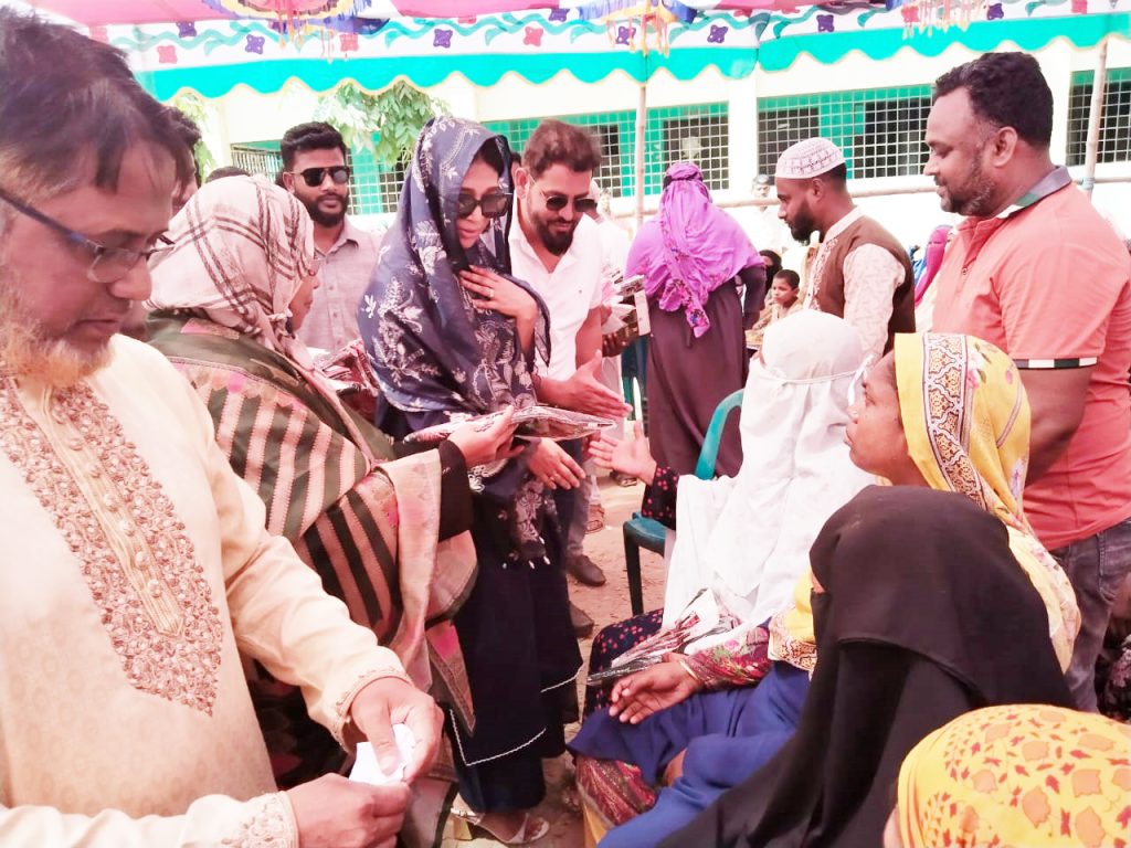 রূপগঞ্জের গোলাকান্দাইলে গাউছিয়া গ্রুপের চেয়ারম্যান মুস্তাফিজুর রহমান ভুঁইয়া দিপু ও তার স্ত্রী ইয়াসমিন ইসমাইল অসহায়দের মাঝে কাপড় বিতরণ করছেন